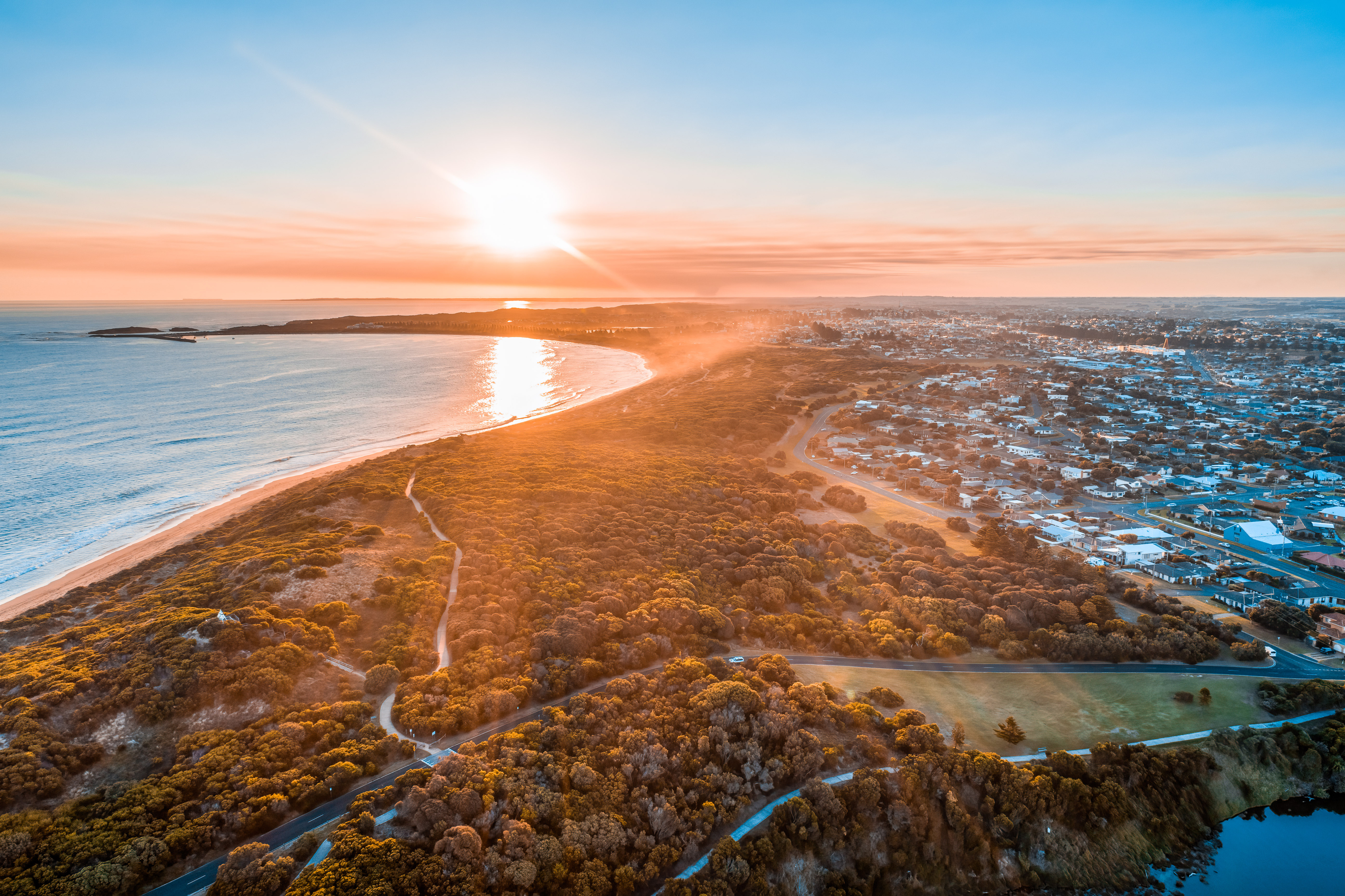 Sunset with sun flare over Warrnambool town and ocean in Australia